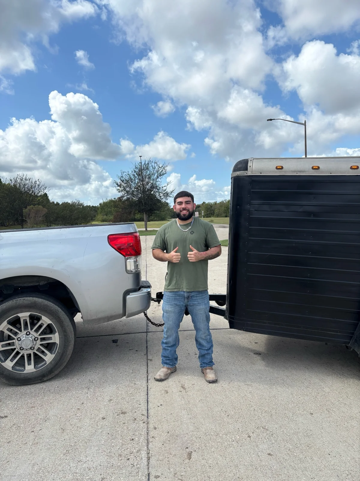 AOA team member standing between the pickup truck and hauling trailer